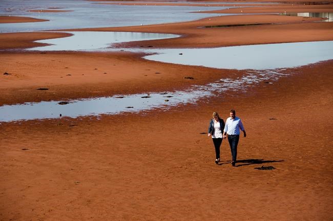 Federal Conservative leader Andrew Scheer and his wife Jill walk on the beach after making a campaign stop in Canoe Cove, P.E.I. on Sunday, September 22, 2019. THE CANADIAN PRESS/Nathan Denette