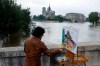 FILE - In this Friday, June 3, 2016 file photo, a man paints the Notre Dame cathedral surrounded by the flooding Seine river in Paris, France. The Gothic structure, which sustained a devastating fire Monday, April 15, 2019, has inspired writers, painters and filmmakers for hundreds of years. (AP Photo/Jerome Delay)