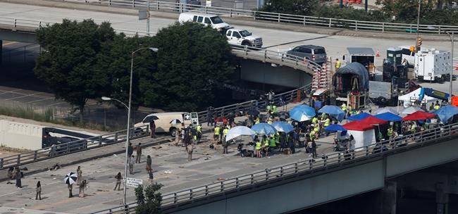 FILE - In this July 8, 2014 photo, actors and extras work during filming of the