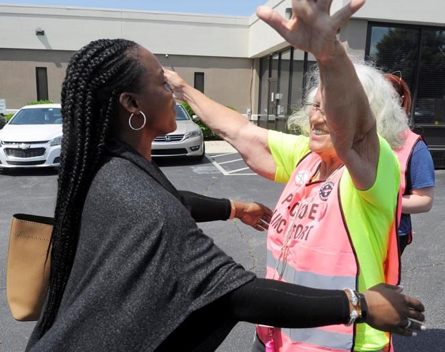 FILE - In this May 17, 2019 file photo, Dr. Yashica Robinson, is greeted with a hug from Josie Poland, a clinic escort, while arriving for work at the Alabama Women's Wellness Center in Huntsville, Ala. Abortion providers are asking a federal judge to block an Alabama law that would ban most abortions in the state. The American Civil Liberties Union and Planned Parenthood filed the lawsuit Friday, May 24 on behalf of Alabama abortion providers seeking to overturn the nation's most stringent abortion law. The plaintiffs in the case are the three Alabama clinics that perform abortions, Planned Parenthood and Robinson, an obstetrician who also provides abortions at the Huntsville clinic. (AP Photo/Eric Schultz, File)