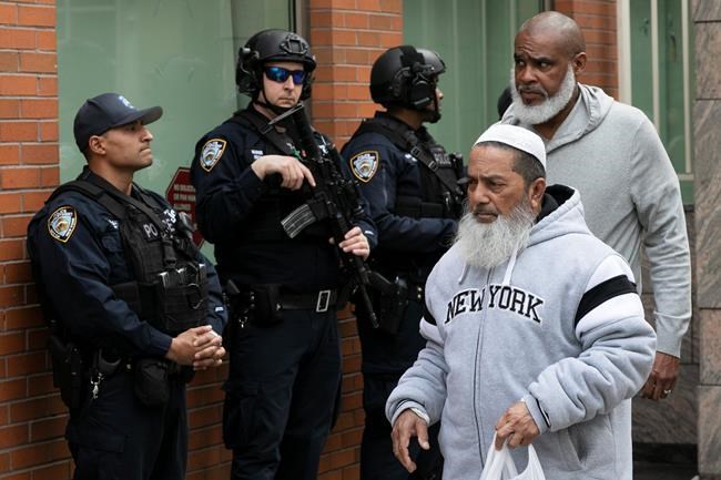 Men leave the Islamic Cultural Center of New York under increased police security following the shooting in New Zealand, Friday, March 15, 2019, in New York. (AP Photo/Mark Lennihan)
