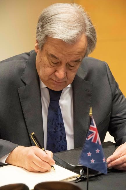 In this Thursday, March 21, 2019, photo provided by the United Nations, United Nations Secretary General Antonio Guterres signs the book of condolence at the New Zealand Mission in New York, for victims of the March 15, 2019, Christchurch mosque shootings. (Evan Schneider/The United Nations via AP)