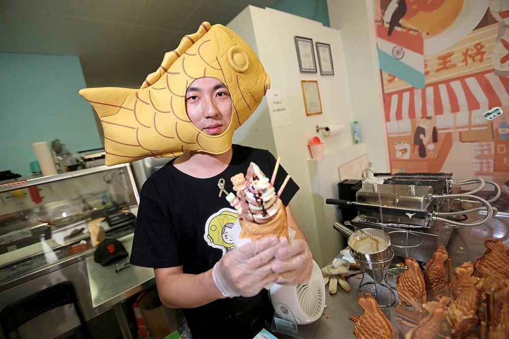 Not a Waffle owner Mu Mu serves up ice cream in Taiyaki, a Japanese cake shaped like a koi fish. (Trevor Hagan / Free Press files)