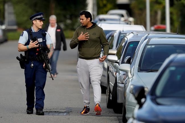 Ash Mohammed, right, talks to a police officer about his father and two brothers who are missing near the Masjid Al Noor mosque, site of one of the mass shootings at two mosques in Christchurch, New Zealand, Saturday, March 16, 2019. (AP Photo/Mark Baker)