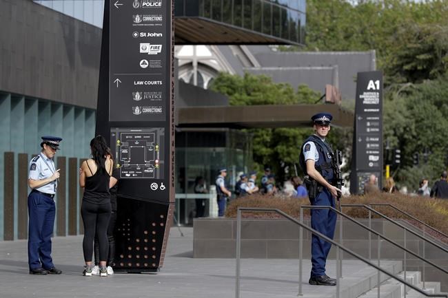 Police stand guard outside the district court building in Christchurch, New Zealand, Saturday, March 16, 2019, where the man believed to be involved in yesterday's mosque shootings will likely appear. (AP Photo/Mark Baker)