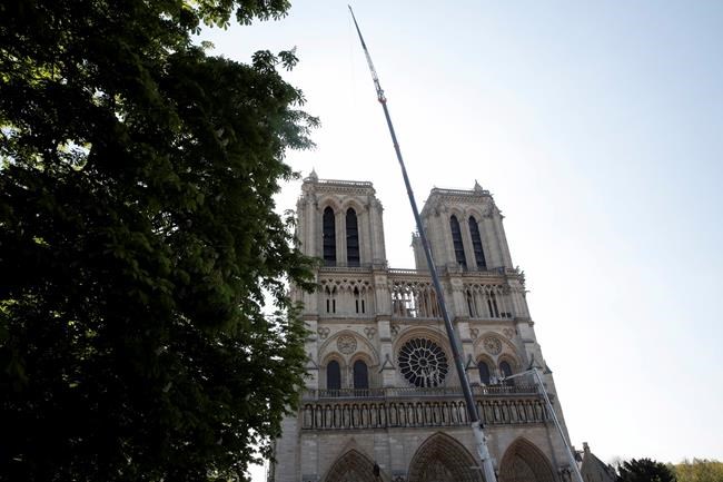 A crane works at Notre-Dame cathedral in Paris, Friday, April 19, 2019. Rebuilding Notre Dame, the 800-year-old Paris cathedral devastated by fire this week, will cost billions of dollars as architects, historians and artisans work to preserve the medieval landmark. (Philippe Wojazer/Pool via AP)
