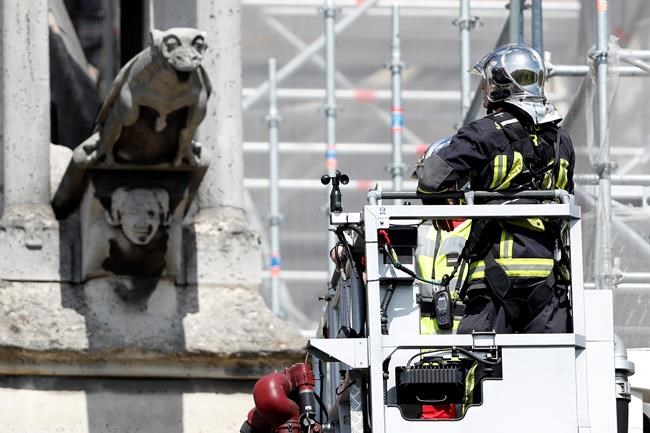 A firefighter watches a preserved gargoyle of Notre Dame cathedral Wednesday, April 17, 2019 in Paris. Notre Dame Cathedral would have been completely burned to the ground in a