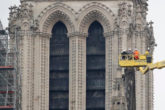 A crane lifts experts as they inspect the damaged Notre Dame cathedral after the fire in Paris, Tuesday, April 16, 2019. Experts are assessing the blackened shell of Paris' iconic Notre Dame cathedral to establish next steps to save what remains after a devastating fire destroyed much of the almost 900-year-old building. With the fire that broke out Monday evening and quickly consumed the cathedral now under control, attention is turning to ensuring the structural integrity of the remaining building. (AP Photo/Christophe Ena)
