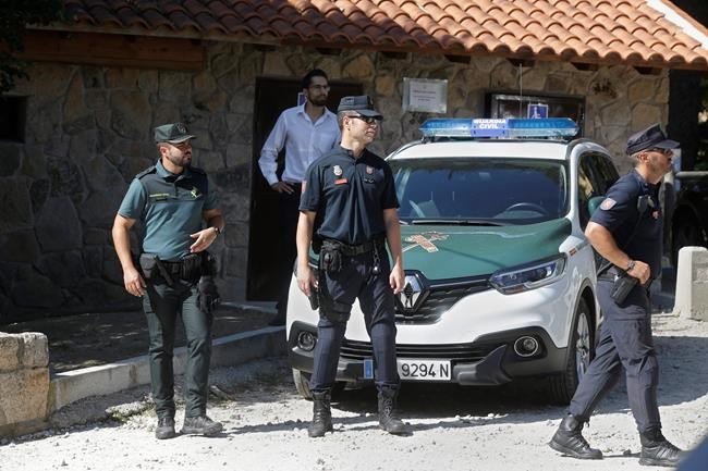 Police wait near a woodland area in Cercedilla, just outside of Madrid, Spain, Tuesday, Sept. 3, 2019. A search squad of hundreds is combing a mountainous area outside Madrid 11 days after former alpine ski racer and Olympic medalist Blanca Fernandez Ochoa went missing.(AP Photo/Paul White)