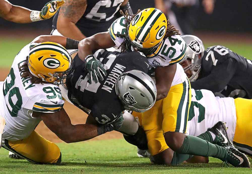 Ben Margot / The Associated Press files
Oakland Raiders running back Chris Warren III, center, is tackled by Green Bay Packers defensive end James Looney (99) and linebacker James Crawford (54) during the second half of an NFL preseason football game in Oakland, Calif., Friday, Aug. 24, 2018.