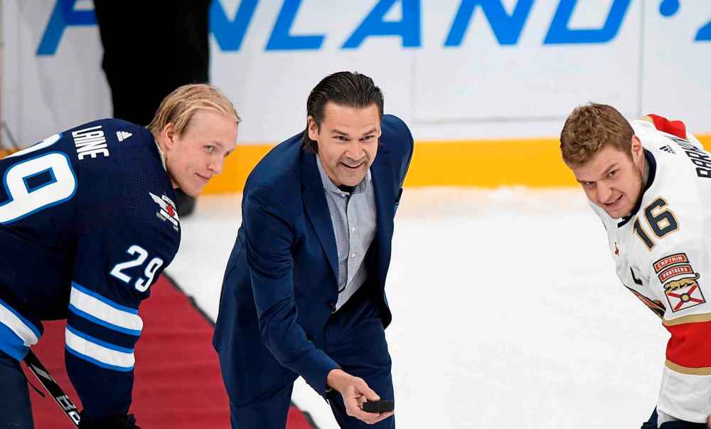 Former Winnipeg Jet Teppo Numminen drops the ceremonial first puck between Patrik Laine (left) and Aleksander Barkov Friday in Helsinki, Finland. (Martti Kainulainen / Lehtikuva)