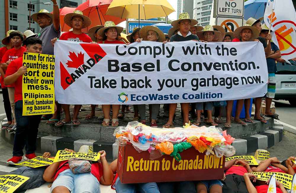 Environmentalists stage a die-in protest in Manila, Philippines last week to demand Canada take home 69 shipping containers of trash that had been mislabelled and illegally shipped to the Philippines as recyclable material. (Bullit Marquez / The Associated Press files)