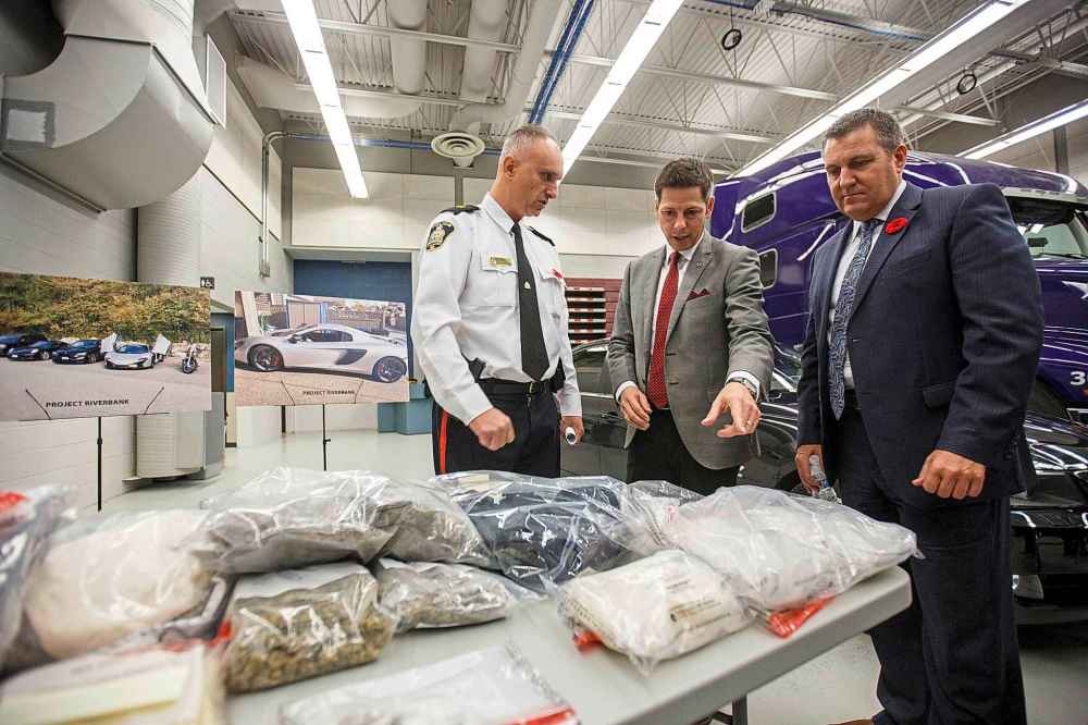 MIKE DEAL / WINNIPEG FREE PRESS
Winnipeg police Inspector Max Waddell talks to Winnipeg Mayor Brian Bowman and Cliff Cullen Minister of Justice and Attorney General at the MPI depot on Plessis Rd Thursday.