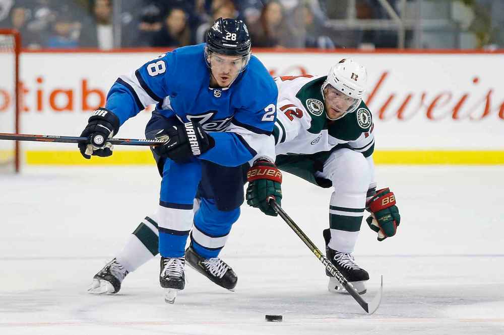 THE CANADIAN PRESS/John Woods
Winnipeg Jets' Jack Roslovic fends off Minnesota Wild's Eric Staal during game action in December. Despite being named the NHL's first star of the week after his first career hat-trick, the Jets' 2015 first-round draft pick also spent some time in the press box.