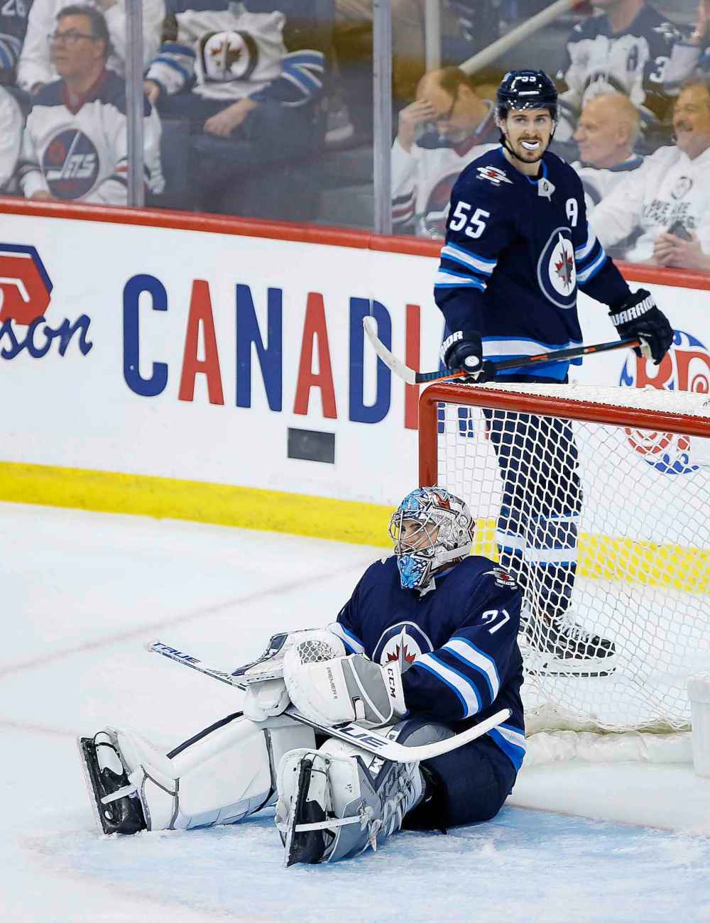 John Woods / THE CANADIAN PRESS FILES
Winnipeg Jets goaltender Connor Hellebuyck and Mark Scheifele look on after the St. Louis Blues scored a game-winning goal with 15 seconds left in the third period to win Game 5 of their opening round playoff series.