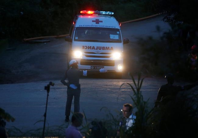 One of two ambulances with flashing lights leaves the cave rescue area in Mae Sai, Chiang Rai province, northern Thailand, Monday, July 9, 2018. The ambulance has left the cave complex area hours after the start of the second phase of an operation to rescue a youth soccer team trapped inside the cave for more than two weeks. (AP Photo/Sakchai Lalit)