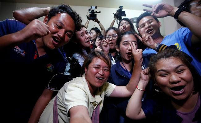 Thai media celebrate after evacuation in Chiang Rai as divers evacuated some of the 12 boys and their coach trapped at Tham Luang cave in the Mae Sai district of Chiang Rai province, northern Thailand, Tuesday, July 10, 2018. Thai Navy SEALs say all 12 boys and their coach were rescued from the cave, ending an ordeal that lasted more than 2 weeks. (AP Photo/Sakchai Lalit)