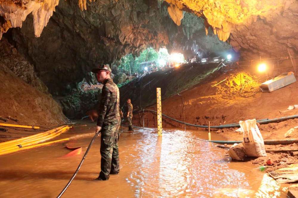 Thai rescue teams arrange water pumping system at the entrance to a flooded cave complex. (Royal Thai Navy via AP)