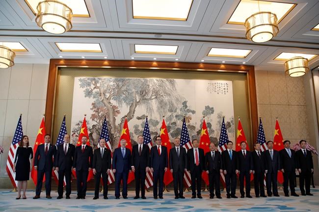 FILE - In this Wednesday, May 1, 2019, file photo, members of U.S. and China delegation led by Chinese Vice Premier Liu He, U.S. Treasury Secretary Steven Mnuchin and U.S. Trade Representative Robert Lighthizer, stand for a group photo session after their meeting at the Diaoyutai State Guesthouse in Beijing. Chinese envoys are preparing to travel to the United States for trade talks, a government spokesman said Monday, May 6, 2019, suggesting negotiations on ending a bruising tariff war will proceed despite President Donald Trump's threat to raise import taxes. (AP Photo/Andy Wong, Pool, File)