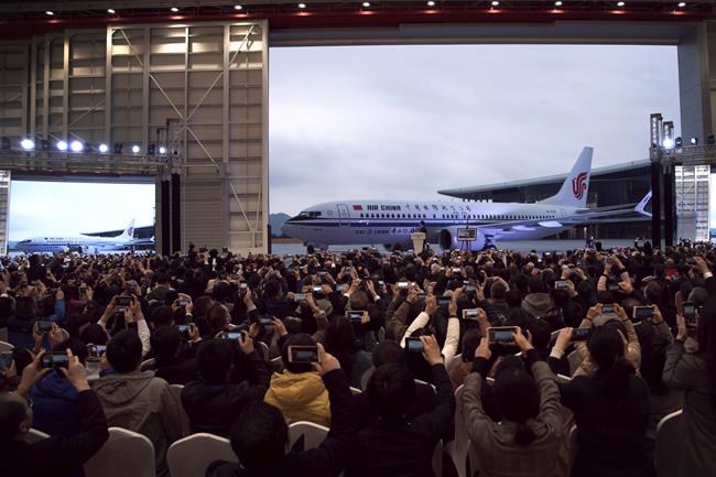 In this Dec. 15, 2018, photo, invited guests take photos of the Boeing 737 Max 8 airplane deliver to Air China during a ceremony at Boeing Zhoushan 737 Completion and Delivery Center in Zhoushan, east China's Zhejiang Province. China's civilian aviation authority has ordered all Chinese airlines to ground their Boeing 737 Max 8 planes on Monday, March 11, 2019 after one of the aircraft crashed in Ethiopia. The authority said the one-day action was made out of safety concerns because the crash was similar to one in Indonesia last year. (Chinatopix via AP)