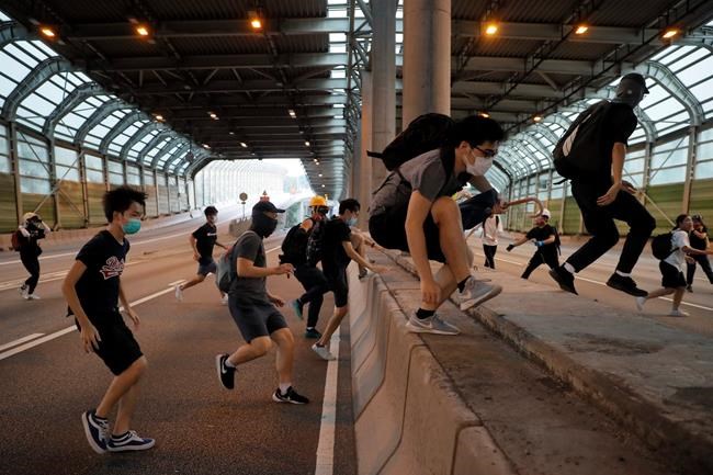 Protesters cross a motorway to prevent police from approaching during a protest Saturday, Sept. 21, 2019, in Hong Kong. Demonstrators have marched through an outlying district of Hong Kong in another weekend of protest aimed at the Chinese territory's government. (AP Photo/Kin Cheung)