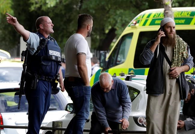 Police attempt to clear people from outside a mosque in central Christchurch, New Zealand, Friday, March 15, 2019. Many people were killed in a mass shooting at a mosque in the New Zealand city of Christchurch on Friday, a witness said. Police have not yet described the scale of the shooting but urged people in central Christchurch to stay indoors.(AP Photo/Mark Baker)