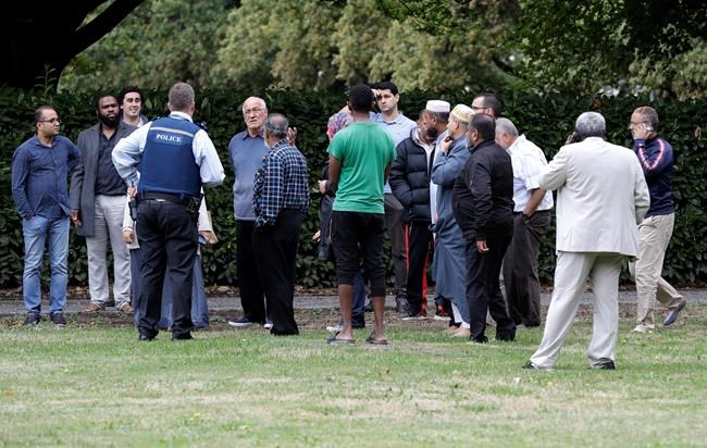 Police talk to witnesses near a mosque in central Christchurch, New Zealand, Friday, March 15, 2019. Multiple people were killed in mass shootings at two mosques full of people attending Friday prayers, as New Zealand police warned people to stay indoors as they tried to determine if more than one gunman was involved.(AP Photo/Mark Baker)
