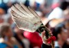 A red ribbon attached to an eagle feather is held up during ceremonies marking the release of the Missing and Murdered Indigenous Women report in Gatineau, Monday June 3, 2019. THE CANADIAN PRESS/Adrian Wyld