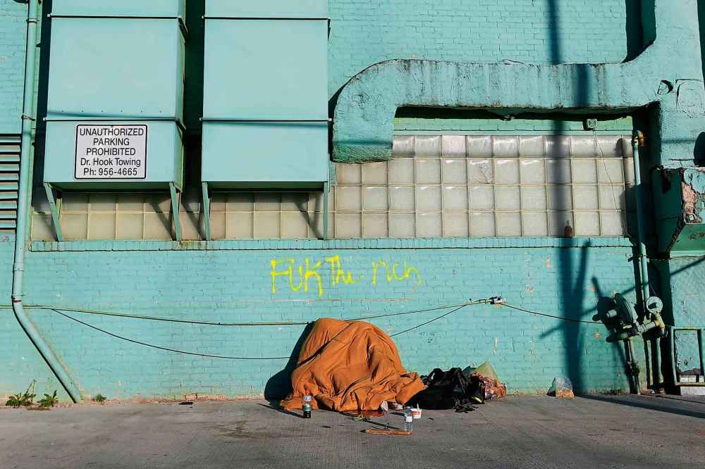 JOHN WOODS / WINNIPEG FREE PRESS FILES
A woman sleeps under a blanket in a backlane in Winnipeg. The shelters are often little more than propped-up tarps providing minimal protection from the elements.