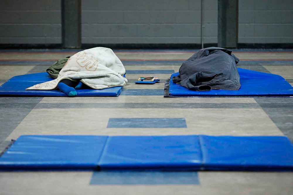 JOHN WOODS / WINNIPEG FREE PRESS
Two people sleep in the temporary shelter that Marion Willis, founder and executive director of St. Boniface Street Links (SBSL) and Morberg House, has set up in the Franco Manitoban Cultural Centre in Winnipeg Monday, March 23, 2020. SBSL is setting up a shelter for unsheltered people in this COVID-19 crisis.
Reporter: Thorpe
