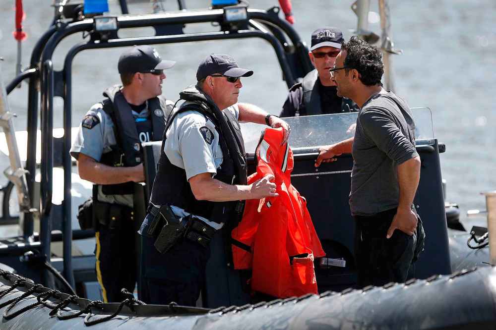 Members of RCMP talk to Ali's brother as they search for him at Belair boat launch Sunday. (John Woods / Winnipeg Free Press)