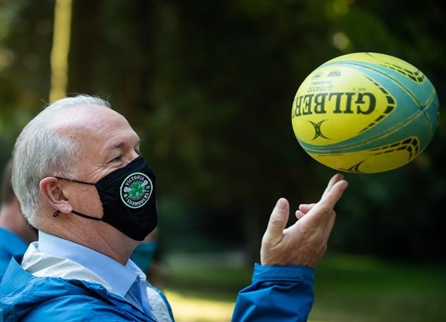 NDP Leader John Horgan spins a rugby ball on his fingers during a campaign stop at Stanley Park, in Vancouver, on Friday, October 2, 2020.THE CANADIAN PRESS/Darryl Dyck