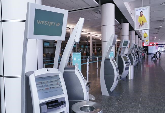 WestJet self service check-in kiosks are seen at Montreal-Trudeau International Airport in Montreal, on Friday, July 31, 2020. THE CANADIAN PRESS/Paul Chiasson