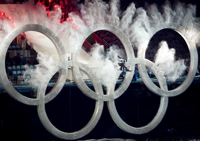 A snowboarder flies through the Olympic rings at the beginning of the opening ceremonies for the XXI Olympic Winter Games in Vancouver, Friday, Feb. 12, 2009. Vancouver's council is considering taking the first small steps toward another Olympic bid. THE CANADIAN PRESS/Nathan Denette