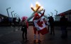 A woman draped in a Canadian flag and other fans gather at the Olympic cauldron as it was lit to commemorate the Canadian men's Olympic team win over Sweden in Vancouver, B.C., on February 23, 2014. City council is scheduled to consider a motion today on whether Vancouver should make a bid for the 2030 Winter Olympics. Coun. Melissa De Genova put the motion forward earlier this year but it was knocked off the agenda by the COVID-19 pandemic. THE CANADIAN PRESS/Darryl Dyck