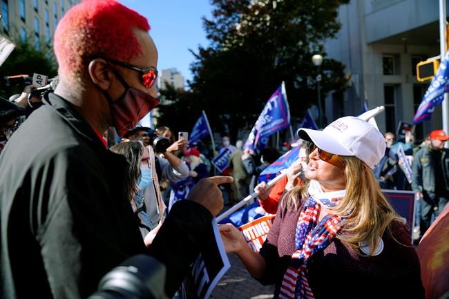 Protesters with opposing viewpoints interact outside the Pennsylvania Convention Center where votes are being counted, Thursday, Nov. 5, 2020, in Philadelphia, following Tuesday's election. Supporters of Donald Trump and Joe Biden are maintaining an uneasy peace in downtown Philadelphia as they await the outcome of the 2020 presidential election. THE CANADIAN PRESS/AP-Matt Slocum