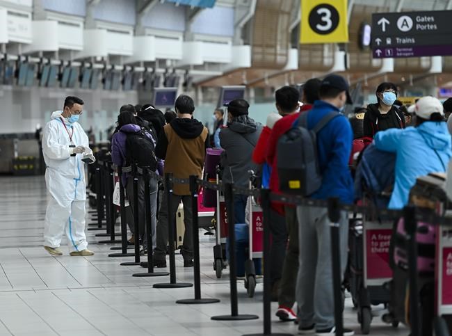 People line up and check in for an international flight at Pearson International Airport during the COVID-19 pandemic in Toronto on Wednesday, Oct. 14, 2020. A report from Canada's transportation regulator says poor preparation by airlines for the country's passenger rights charter resulted in communication problems that frustrated travellers and denied some their proper compensation following flight delays or cancellations. THE CANADIAN PRESS/Nathan Denette