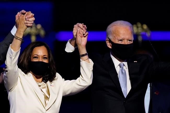 Vice President-elect Kamala Harris holds hands with President-elect Joe Biden and her husband Doug Emhoff as they celebrate, in Wilmington, Del., Saturday, Nov. 7, 2020. Federal cabinet ministers are welcoming Joe Biden election as the next U.S. president as an opportunity to advance the fight against climate change. THE CANADIAN PRESS/AP-Andrew Harnik