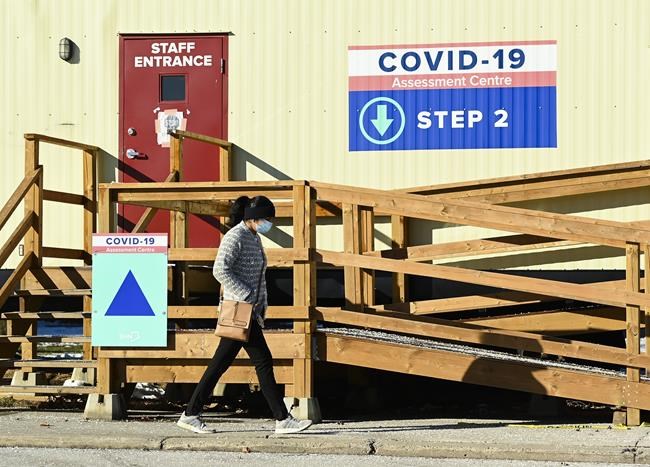 A person walks past a COVID-19 assessment centre during the COVID-19 pandemic in Scarborough, Ont., on Wednesday, December 2, 2020. Toronto and Peel region continue to be in lockdown. THE CANADIAN PRESS/Nathan Denette