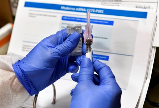 Nurse Kath Olmstead prepares a shot as the world's biggest study of a possible COVID-19 vaccine, developed by the National Institutes of Health and Moderna Inc., gets underway Monday, July 27, 2020, in Binghamton, N.Y. U.S. biotech firm Moderna says its vaccine is showing signs of producing lasting immunity to COVID-19, and that it will have as many as many as 125 million doses available by the end of March. THE CANADIAN PRESS/AP-Hans Pennink