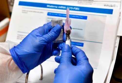 Nurse Kath Olmstead prepares a shot as the world's biggest study of a possible COVID-19 vaccine, developed by the National Institutes of Health and Moderna Inc., gets underway Monday, July 27, 2020, in Binghamton, N.Y. U.S. biotech firm Moderna says its vaccine is showing signs of producing lasting immunity to COVID-19, and that it will have as many as many as 125 million doses available by the end of March. THE CANADIAN PRESS/AP-Hans Pennink