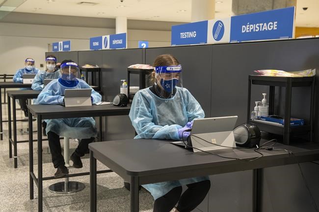 Workers prepare to greet passengers at the COVID-19 testing centre in the International Arrivals area at Pearson Airport in Toronto, Tuesday, Jan. 26, 2021. The federal Liberal government unveiled new restrictions on travel Friday designed to slow the spread of COVID-19. THE CANADIAN PRESS/Frank Gunn
