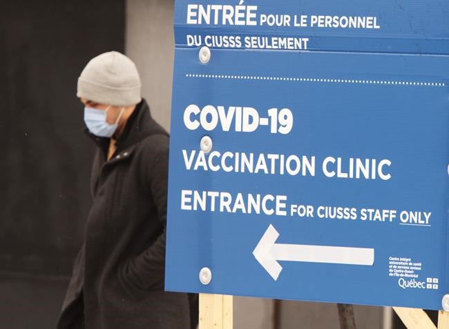 A man walks past the COVID-19 vaccination site at Maimonides long term care facility Wednesday, January 13, 2021 in Montreal. THE CANADIAN PRESS/Ryan Remiorz