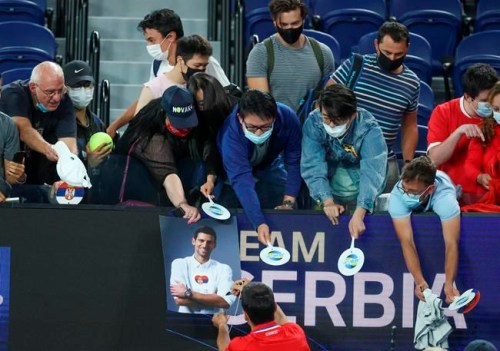 Serbia's Novak Djokovic signs autographs after defeating Germany's Alexander Zverev in their ATP Cup match in Melbourne, Australia, Friday, Feb. 5, 2021.THE CANADIAN PRESS/AP/Hamish Blair