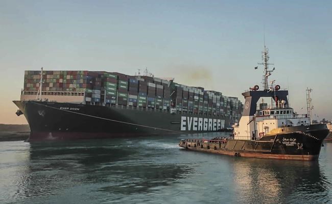 In this photo released by Suez Canal Authority, the Ever Given, a Panama-flagged cargo ship, is pulled by one of the Suez Canal tugboats, in the Suez Canal, Egypt, Monday, March 29, 2021. Engineers on Monday