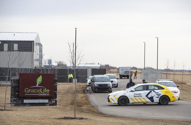 Security and police block the entrance to GraceLife Church as a fence goes up around it near Edmonton on Wednesday, April 7, 2021. The Alberta government has closed down the church that has been charged with refusing to follow COVID-19 health rules. Alberta Health Services, in a statement, said GraceLife church will remain closed until it shows it can and will comply with public-health measures meant to contain the spread of the novel coronavirus. THE CANADIAN PRESS/Jason Franson