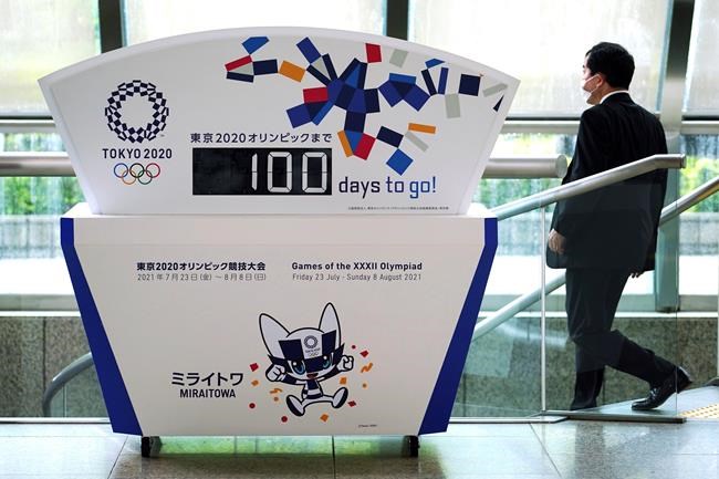 A man wearing a protective mask to help curb the spread of the coronavirus walks past banners for the Tokyo 2020 Olympic and Paralympic Games in Tokyo, Wednesday, April 14, 2021, to mark 100 days before the start of the Summer Games. THE CANADIAN PRESS/AP, Eugene Hoshiko