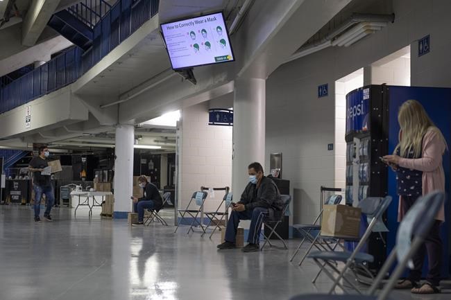 Patients wait in a designated area after receiving their shot at the Saskatoon Tribal Council run vaccination clinic inside SaskTel centre in Saskatoon, Sask., on Thursday, April 15, 2021. THE CANADIAN PRESS/Kayle Neis