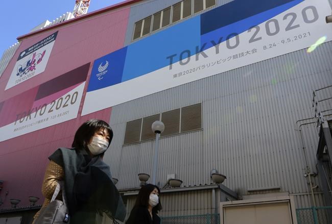 FILE - In this Feb. 24, 2021, file photo, people walk past posters to promote the Olympic Games scheduled to start in the summer in Tokyo. Frustration is mounting over Japanese Prime Minister Yoshihide Suga’s request that people cooperate while he pushes to hold the Olympics in just over two months. (AP Photo/Koji Sasahara, File)