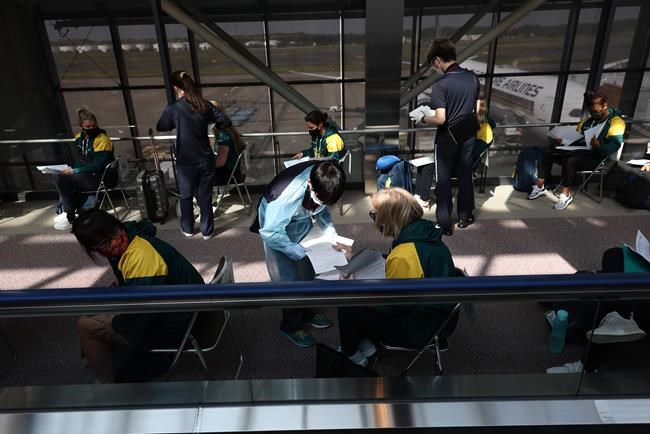 Australian softball national team players wait for antigen test after arriving at the Narita International Airport in Narita, Chiba prefecture, Tuesday, June 1, 2021. The Australian team is one of the first teams to arrive ahead of the Tokyo 2020 Olympic games, scheduled to open July 23. (Behrouz Mehri/Pool Photo via AP)